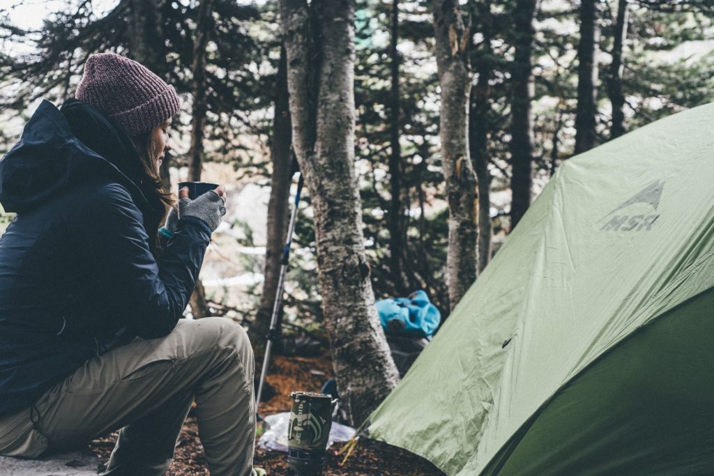 Person cooking at a backcountry campsite. How to choose backpacking meals.