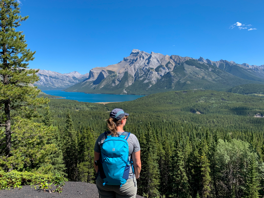 A woman stands at a viewpoint about Lake Minnewanka in Banff National Park