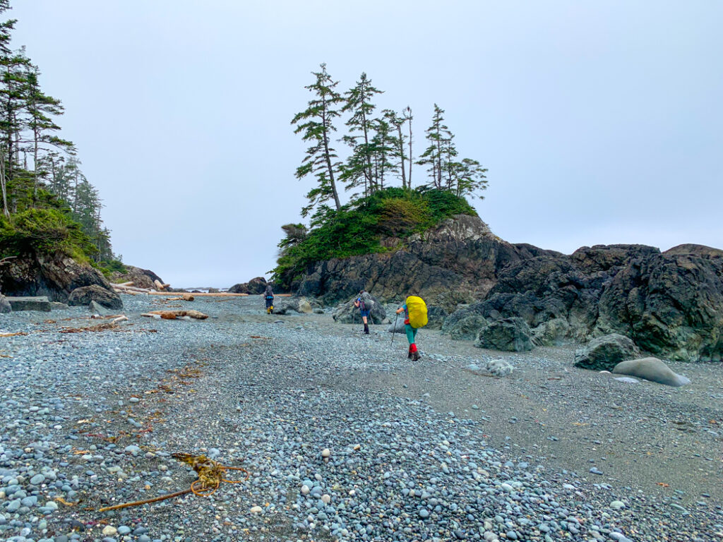 Hiking on a pocket beach on the North Coast Trail near Cape Sutil