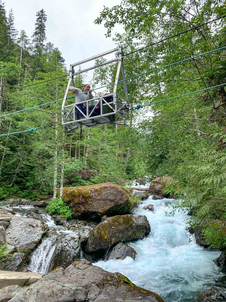 A hiker rides the cable car across Drinkwater Creek