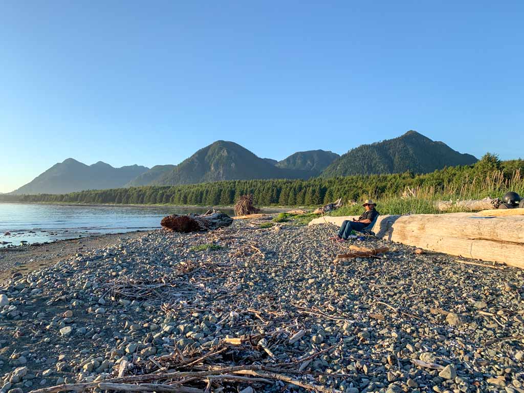 A hiker relaxes on a chair at Tatchu Creek - leaving behind luxuries is one way to reduce your backpack weight