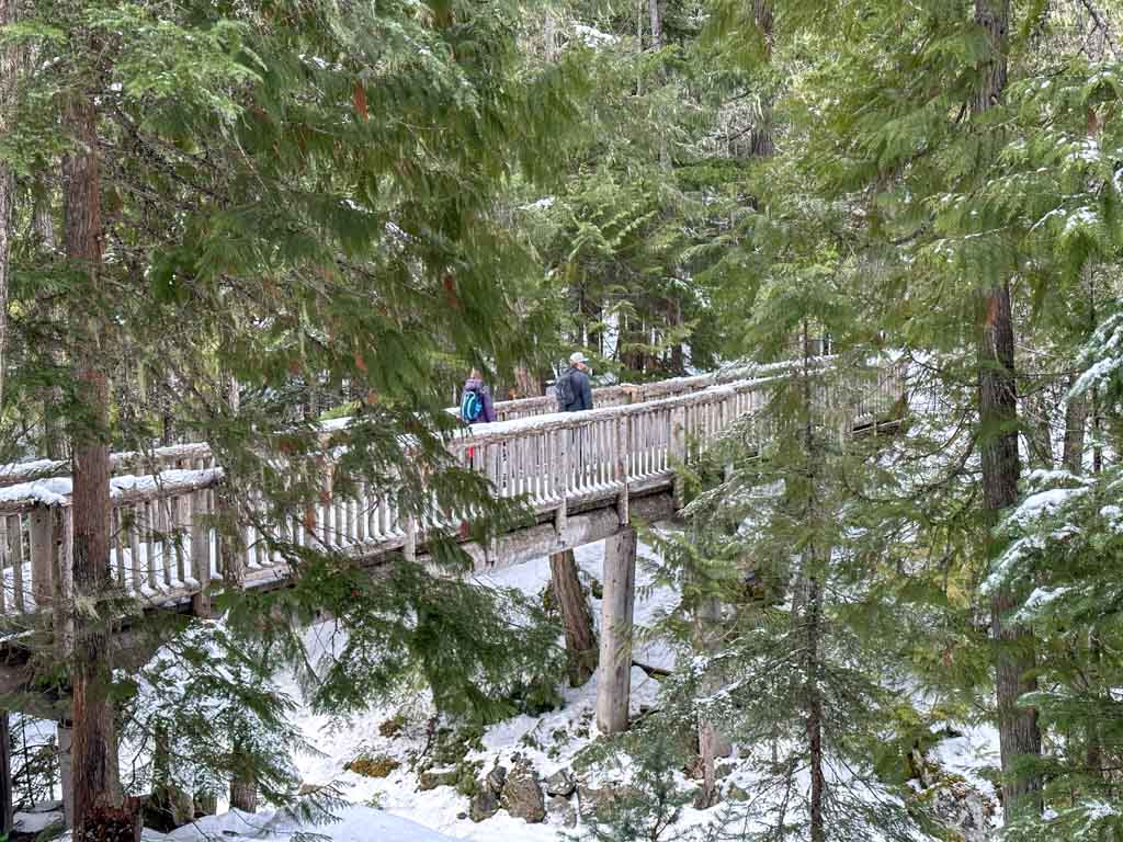 Snowshoers crossing a bridge at Lost Lake Park in Whistler