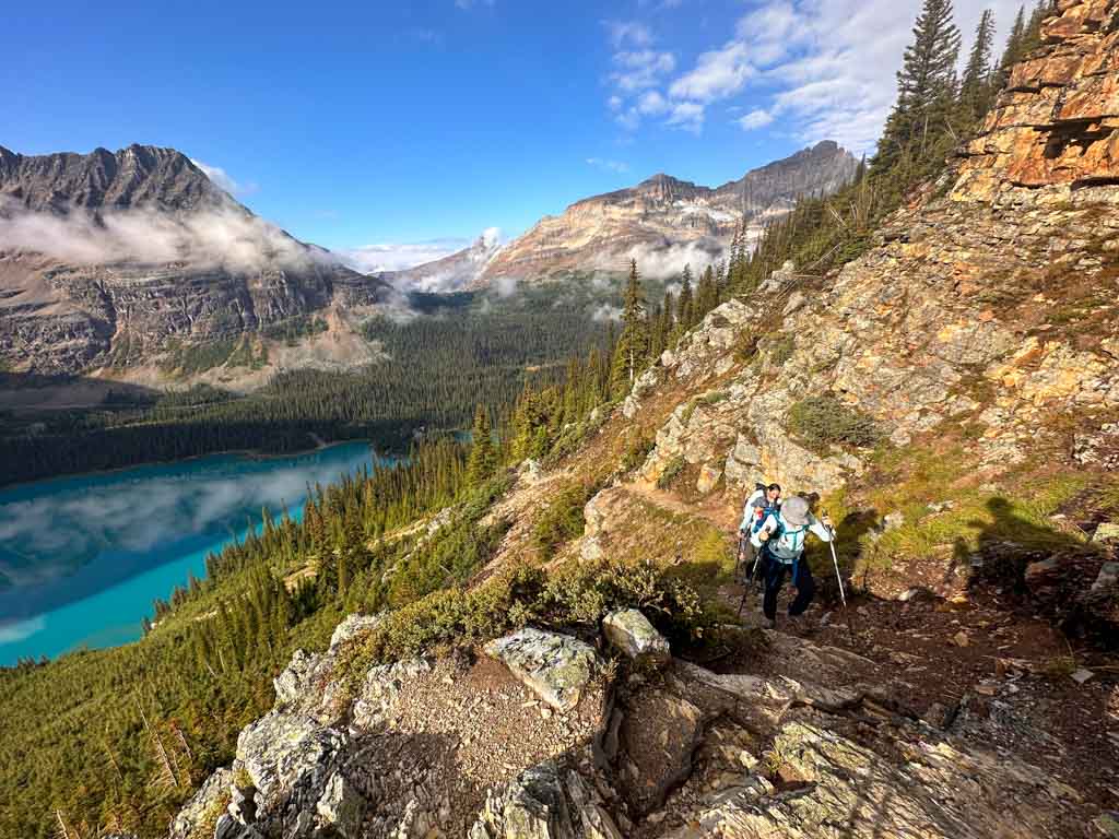 Hikers climb over rock steps on the Wiwaxy Gap Trail