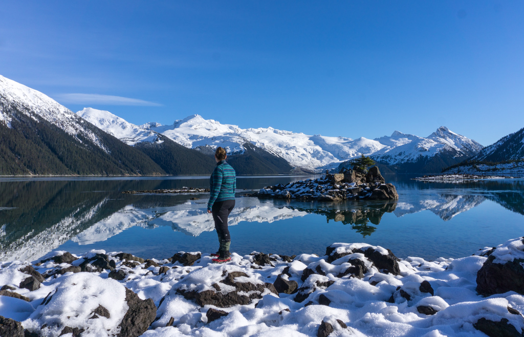 A woman wears a Merino wool jacket in the winter at Garibaldi Lake