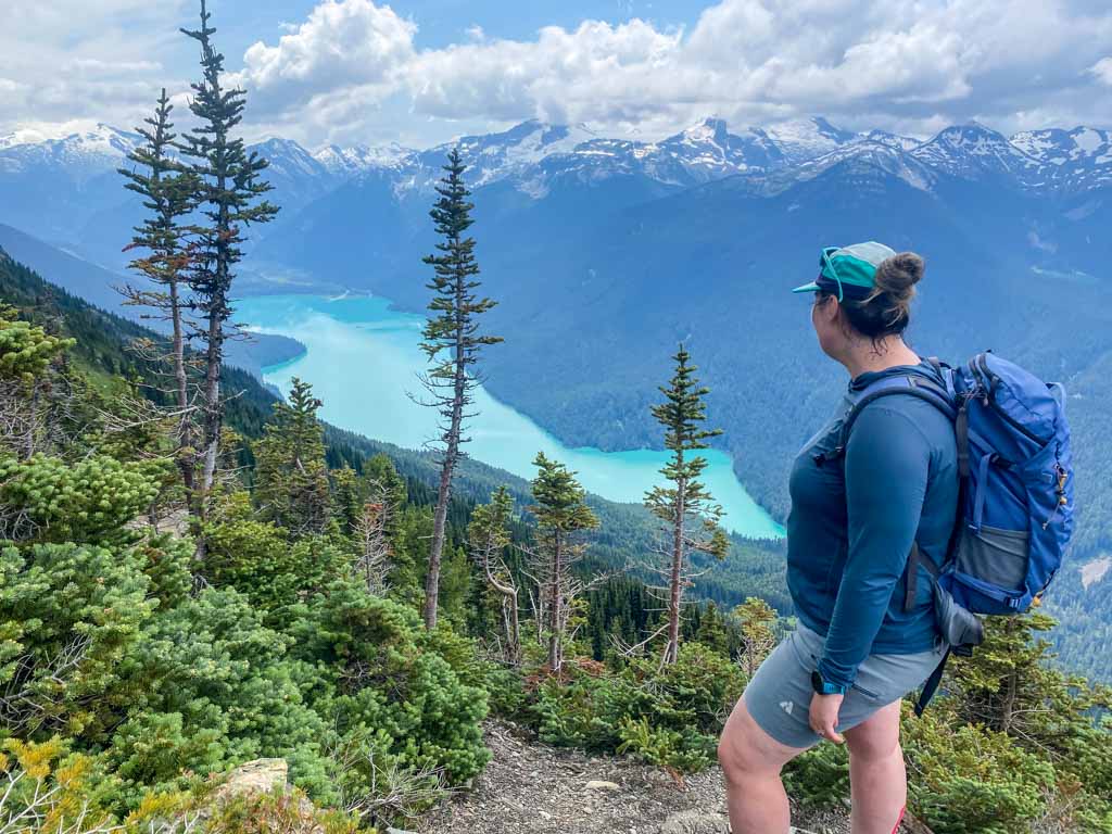 A hiker looks down at a lake from the top of the High Note Trail in Whistler
