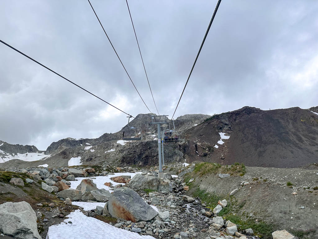View of rocks, snow, and cliffs from the Peak Chair at Whistler, BC in summer hiking season