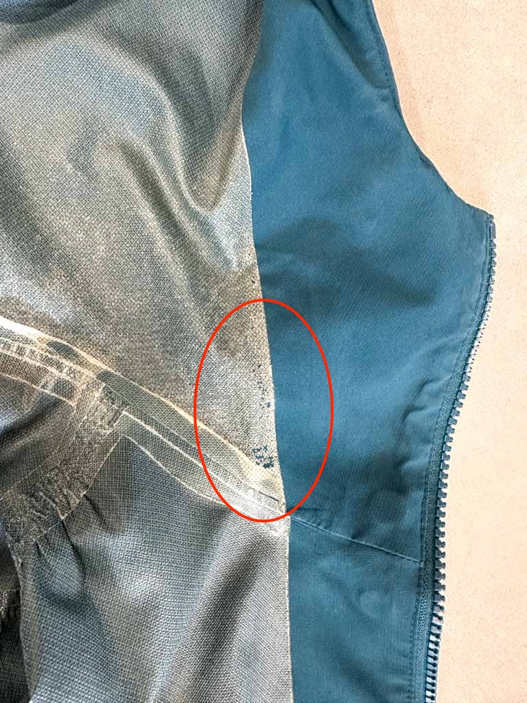 A hiking rain jacket with a membrane that is starting to flake off and fail