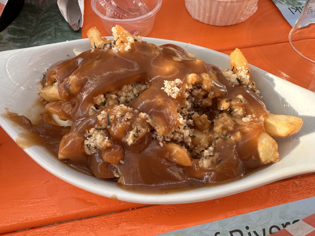 A close up of a dish of fries with gravy and dressing, a signature dish in Newfoundland cuisine