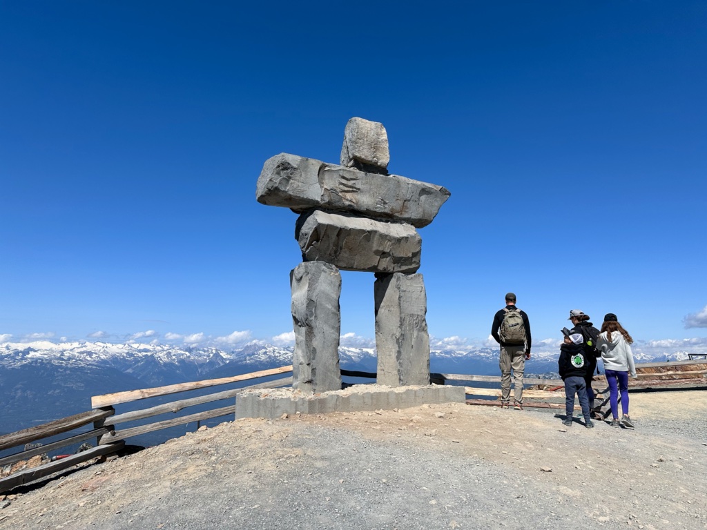 People take photos with the inukshuk on Whistler Peak