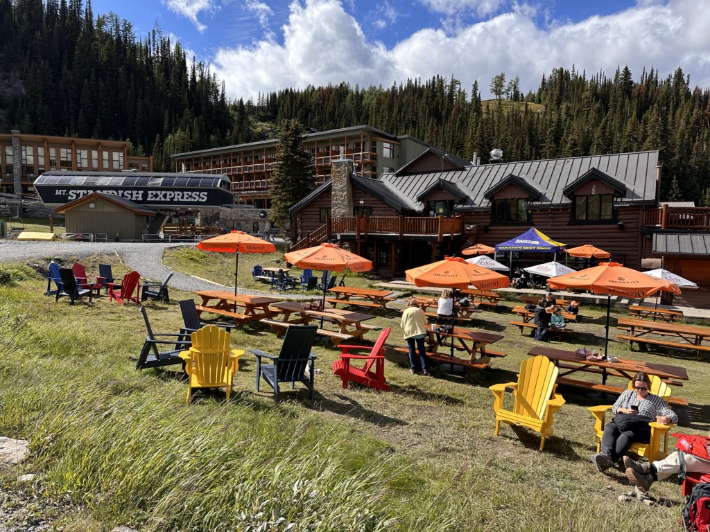 People sitting on at picnic tables outside the Mad Trapper's Grill at Sunshine Village
