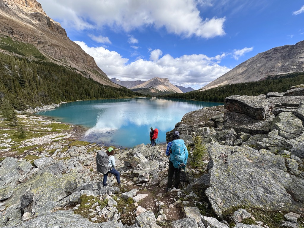 A group of hikers at Myotosis Lake on the Skoki Loop in Banff National Park