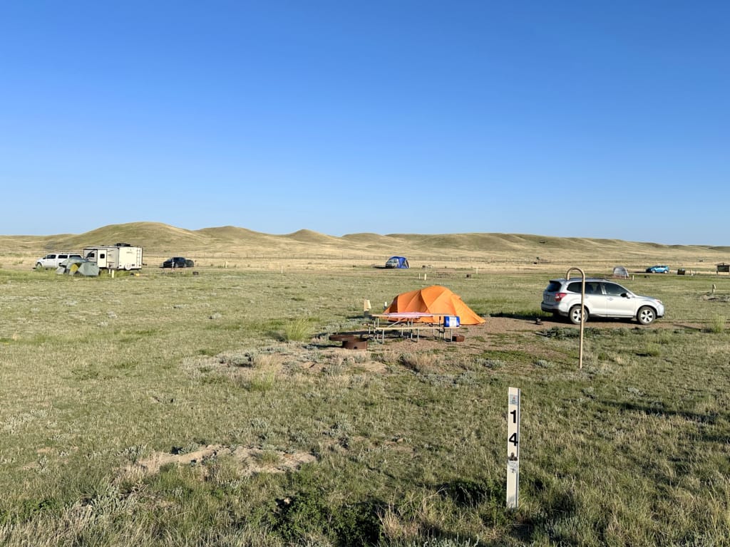 An orange tent next to a SUV at the Frenchman Valley Campground in Saskatchewan