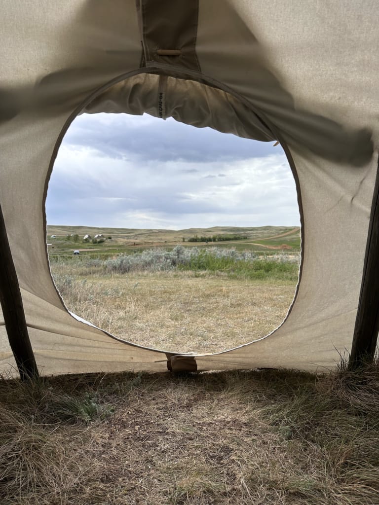 Looking out through the door of a tipi at Rock Creek in Grasslands National Park