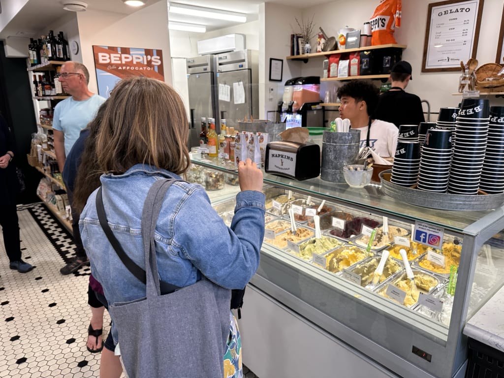 Customers stand in front of the gelato case at Beppi's Gelato