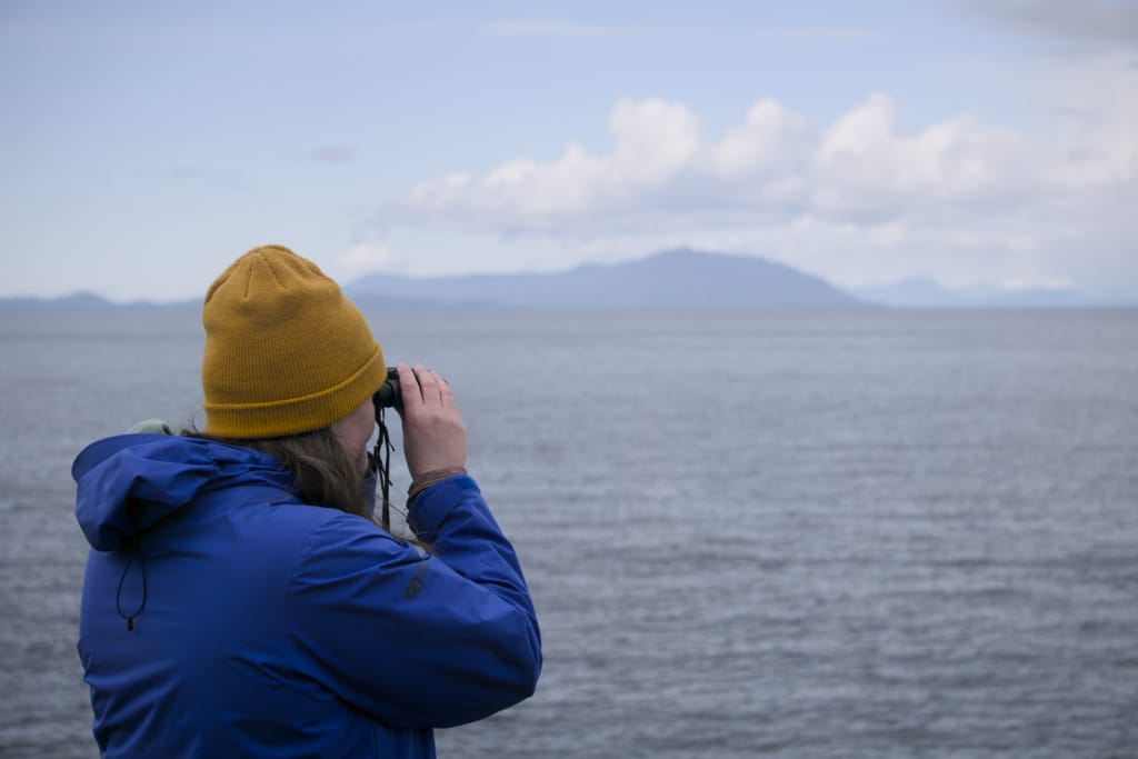 A woman looks through binoculars