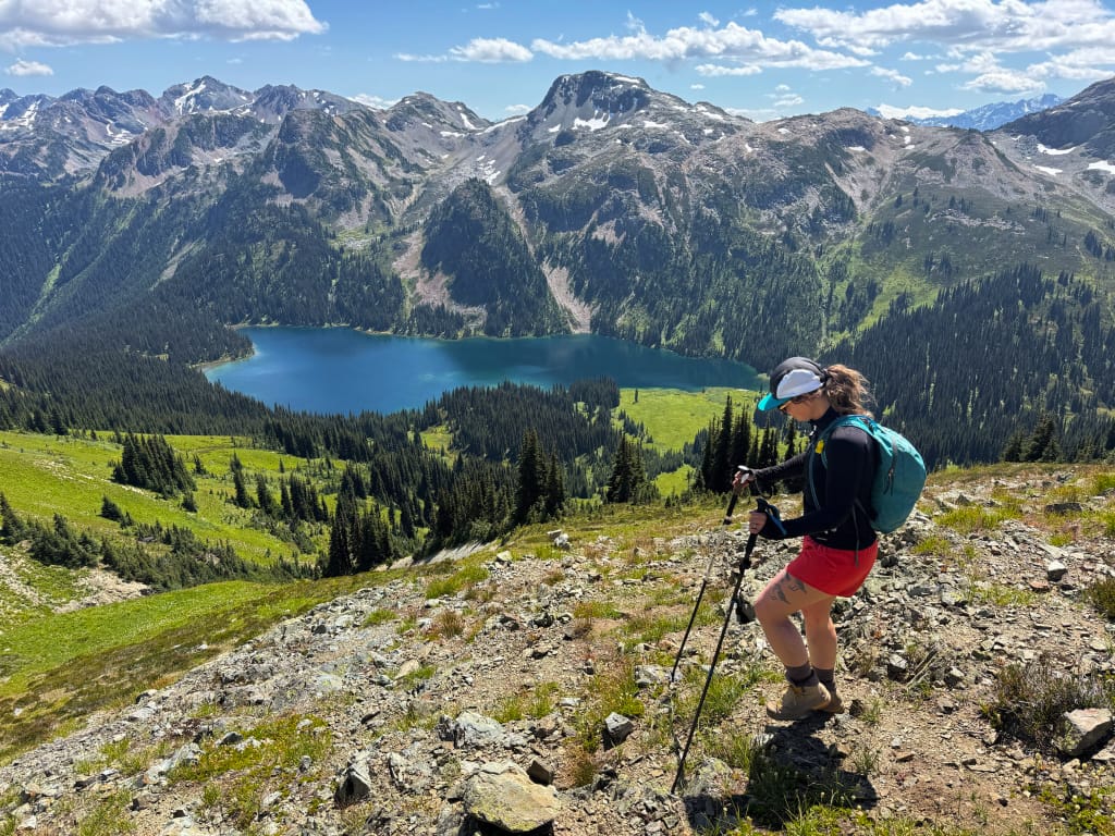 A hiker walks along an alpine ridge high above Tenquille Lake near Pemberton