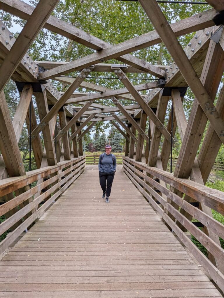 A woman walks across a bridge at Cottonwood Island Nature Park in Prince George