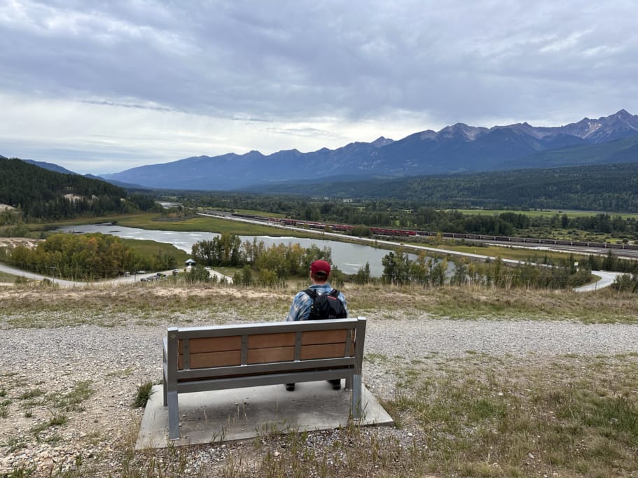 A man sits on a bench overlooking Reflection Lake in Golden, BC