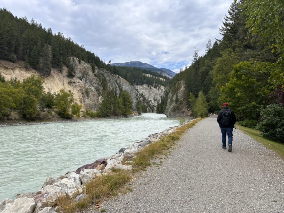 A man walks along the Rotary Trail in Golden beside the Kicking Horse River. The trail is part of the Golden Stroll self-guided walking tour.